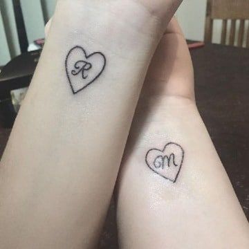 Tatuagens de letras e iniciais nos pulsos para corações de casais e letras internas R e m