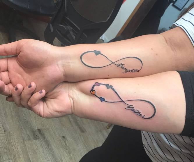 Tattoos von Müttern und Kindern und Unendlichkeitssymbol an beiden Handgelenken mit Herzaufschrift „Mutter und Tochter, Mutter und Tochter“.