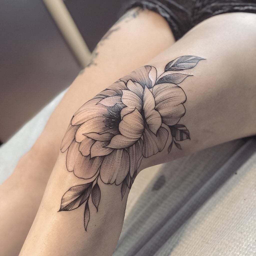 Tatuajes en la Rodilla Flor grande con hojas negras