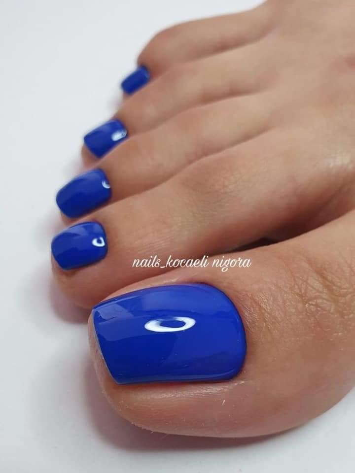 Algumas unhas de acrílico azul brilhante nos dedos dos pés