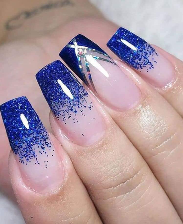 Some Blue Acrylic Nails with blue glitter on the tips and geometric ornaments