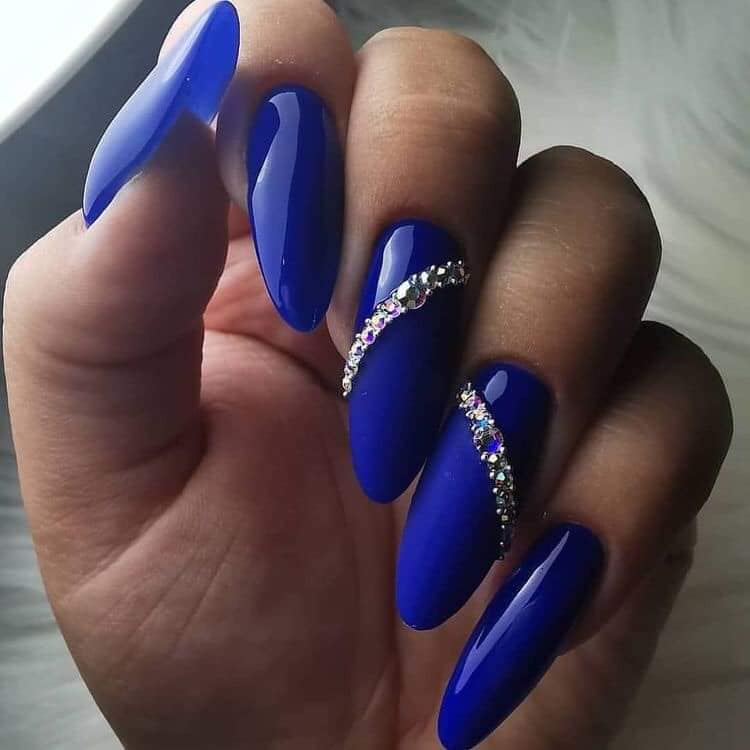 Algumas unhas de acrílico azul com uma pulseira brilhante