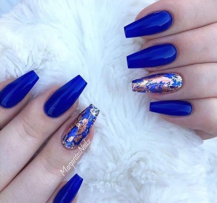 Quelques ongles en acrylique bleu en bleu profond et un avec des décorations marbrées dorées 1