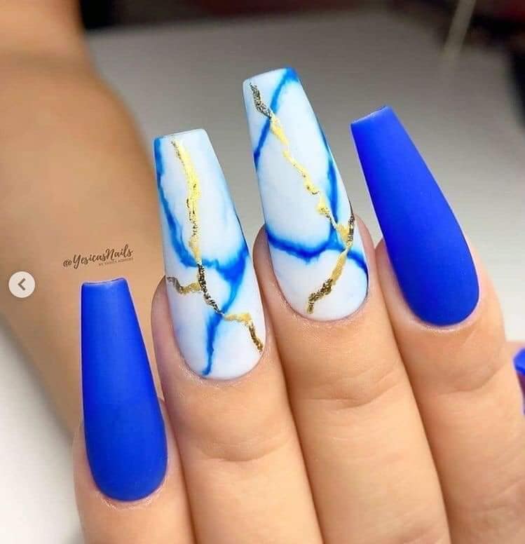 Certains ongles en acrylique bleu type pierre de marbre avec des veines bleues et dorées