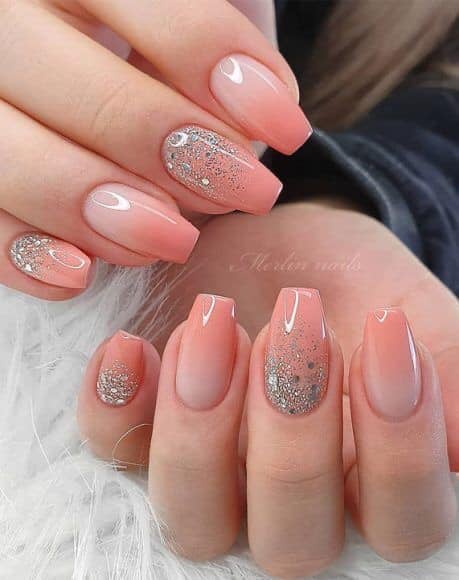 Alcune unghie acriliche rosa sfumate con glitter argento