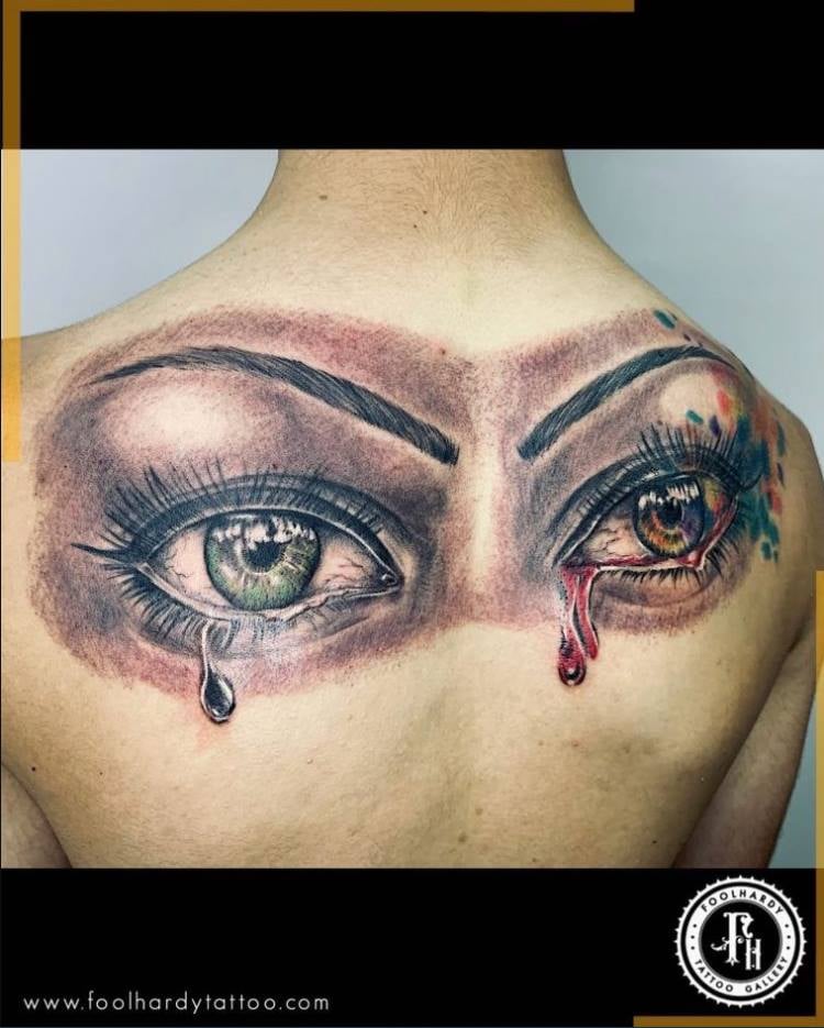 Tollkühne Tattoo-Galerie auf der Rückseite, auf den Schulterblättern, zwei Augen mit grünen und roten Tränen