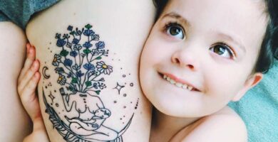 1 TOP 1 Tatuajes de Madres e Hijos Madre amamantando con cabeza de planta flores luna sobre una pluma en muslo 1 1