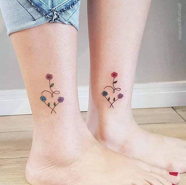 1 TOP 1 Tatuajes para mejores amigas emparejados en pantorrilla corazon hecho de fino trazo con florcitas rojas celestes y violetas