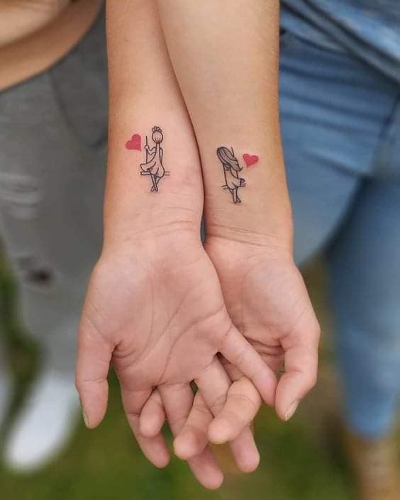 3 TOP 3 Tattoos für beste Freunde am Handgelenk, die in einer Hängematte sitzen, mit kleinen roten Herzen