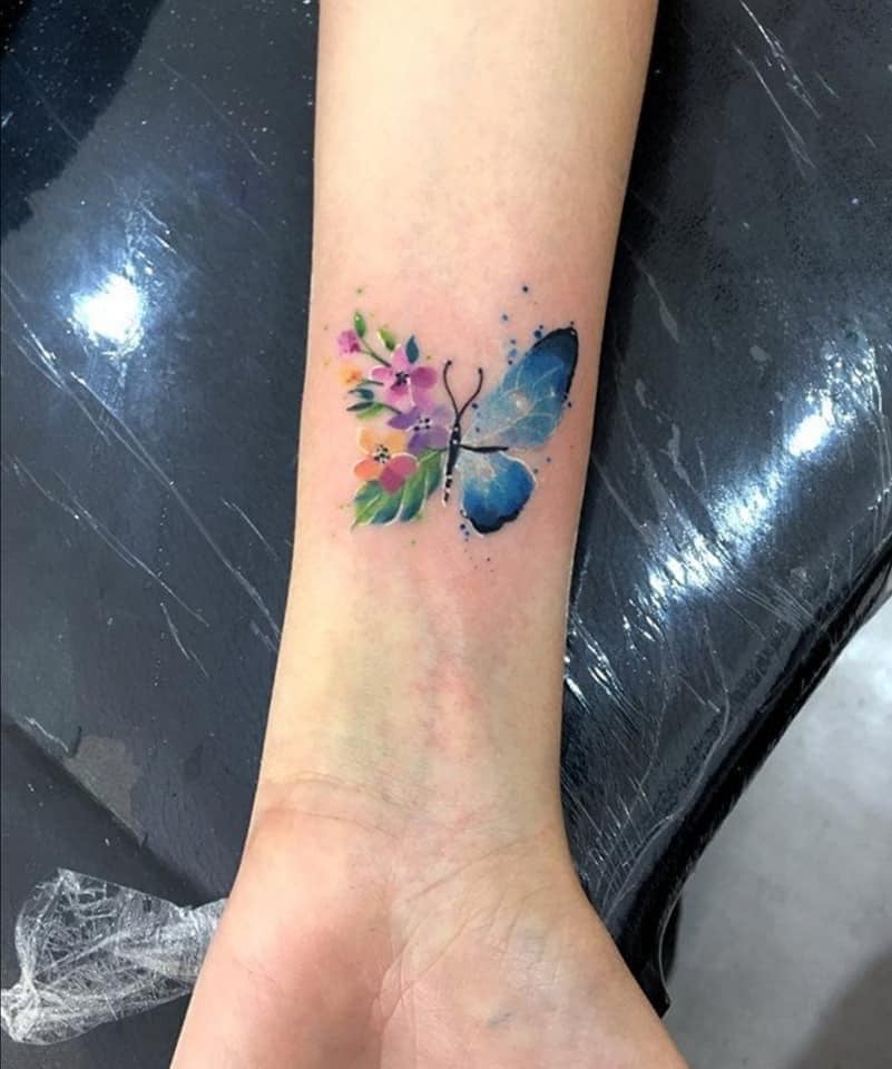 31 Schmetterlings-Tattoos am Handgelenk, halb kleine Blumen in vielen Farben, halb himmlisch mit Schwarz