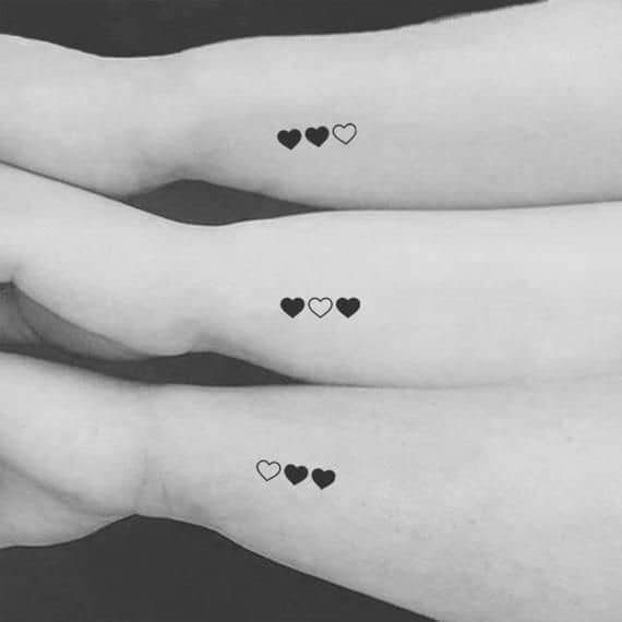 33 Tattoos für Schwestern und Freunde. Drei gefüllte und nicht gefüllte Herzen auf dem Unterarm
