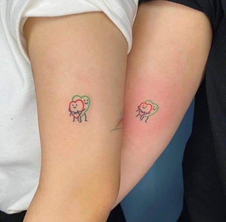 34 Tattoos for Sisters Friends Small green and red embraced hearts with a face on the arm
