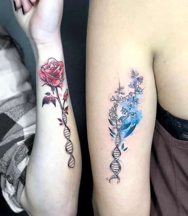 6 tatuagens em aquarela para melhores amigos em ambos os braços em um uma rosa vermelha com DNA e em outro algumas flores celestiais com DNA