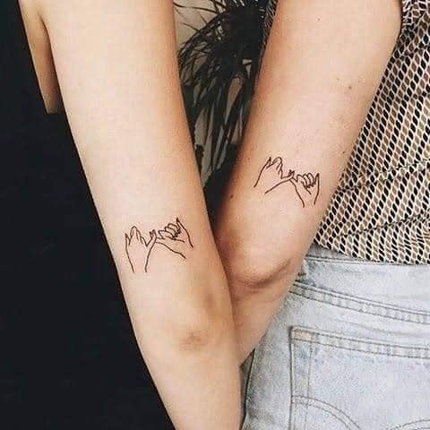 9 tatuagens para melhores amigas duas mãos com dedos entrelaçados na parte de trás do braço