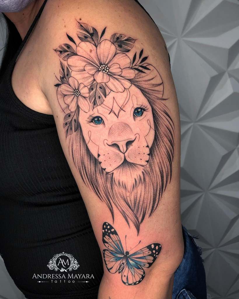 Tätowierung eines Löwen mit Schmetterling und schwarzen Blumen auf dem Arm