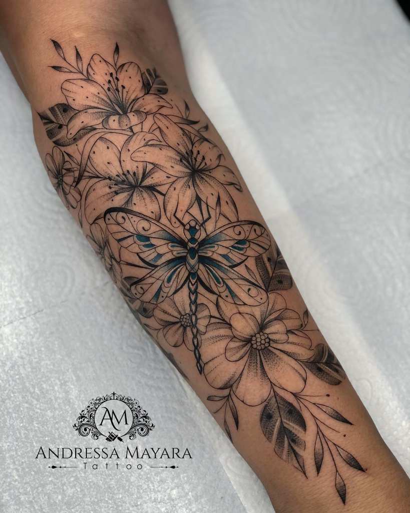 Tatuaje de Libelula en la naturaleza entre Flores y hojas Artista Andressa Mayara Santa Catarina Brasil