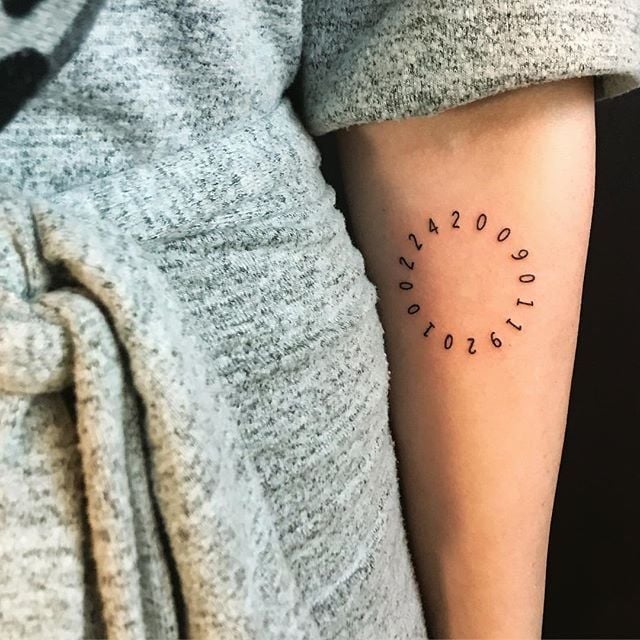 Tatouages de dates en forme de cercle sur le bras