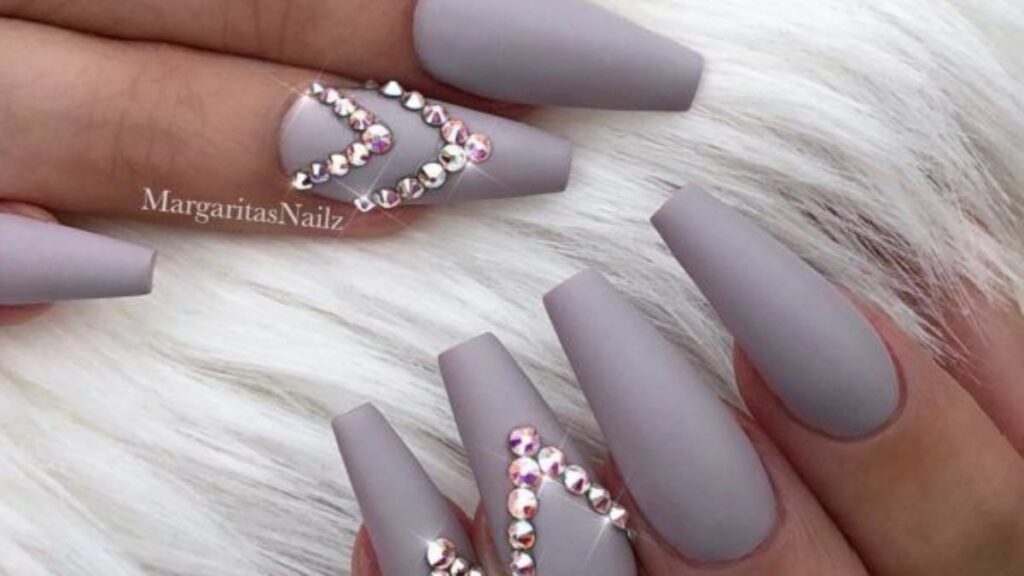 Gray decorated nails with silver strass in the shape of a triangle