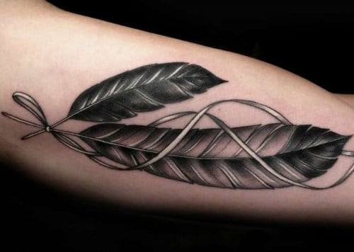 10 Tatuajes Significativos dos plumas negras con una cinta blanca es un amuleto de proteccion y buena suerte para dos personas que se aman
