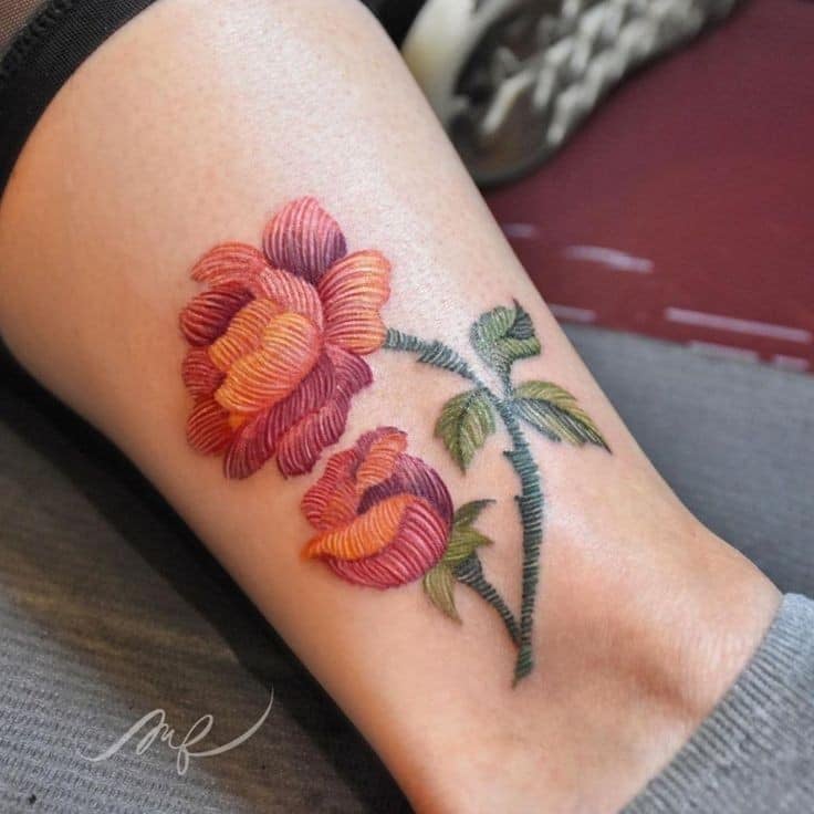 13 gestickte Tattoos der Künstlerin Fernanda Alvarez Art Mexico Blume und Setzling Orange und rotgrüner Stiel auf der Wade
