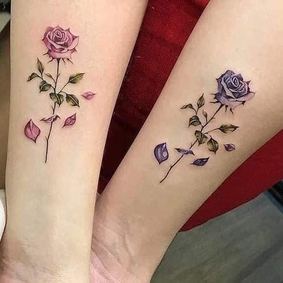 14 Cute Tattoo Ideas for couples, sisters, friends, pink and violet flowers on each forearm, delicate with petals and green leaves