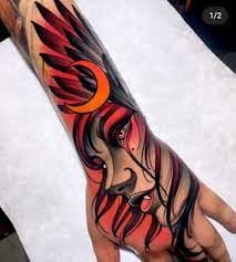 15 Profil de tatouage néotraditionnel du visage de la femme avec des plumes rouges colorées de lune orange sur la main et l'avant-bras