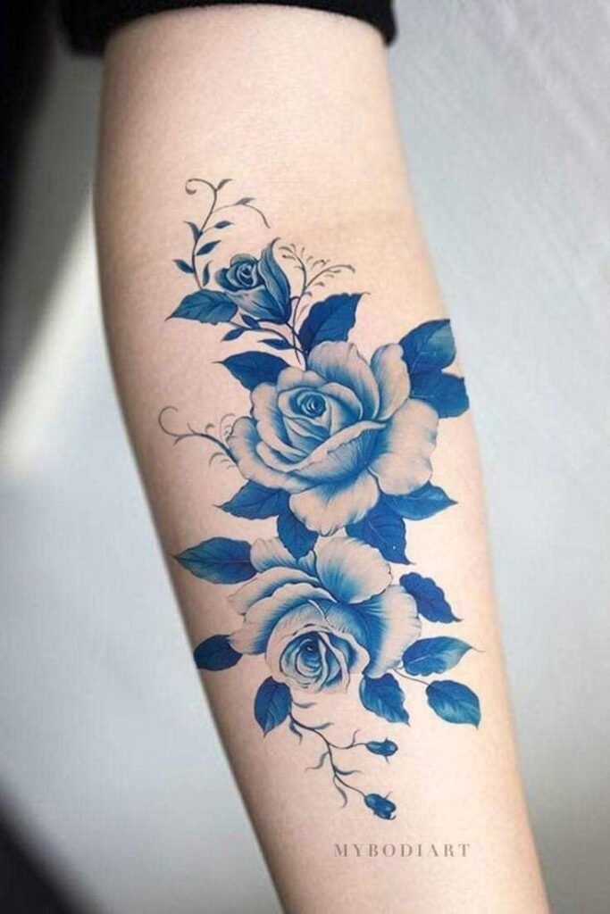 29 Tatuagens Rosas Azuis com botões, folhas, ramos no antebraço