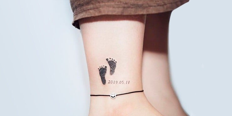 5 TOP 5 Tatuajes Significativos los piecitos de nuestro hijo plasmados en tinta negra en tobillo con fecha de nacimiento