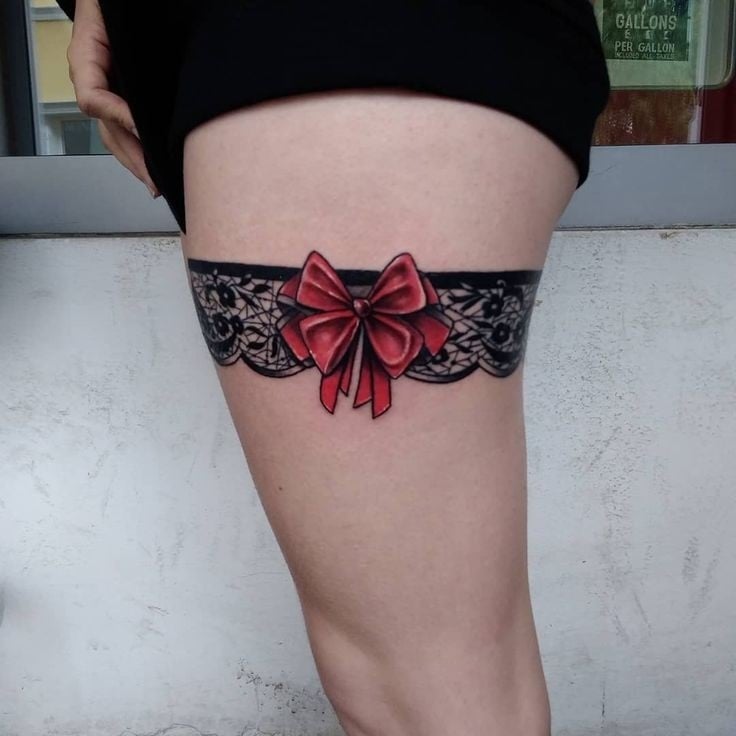 Suspensório de mulher 5 tatuagens na coxa com macacão vermelho