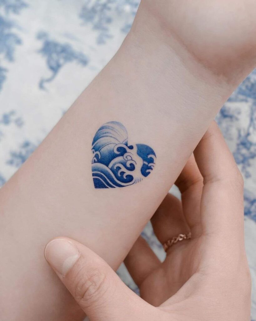 79 tatuagens com coração de tinta azul no pulso com ondas do mar dentro