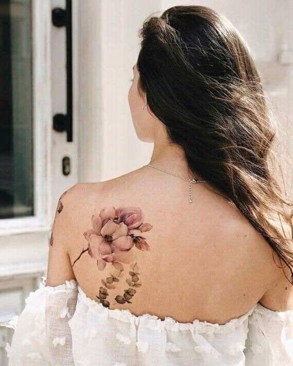 88 Cute Cherry Blossom Tattoos on the shoulder blade of a woman with falling petals