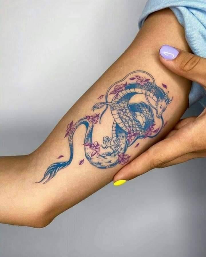 9 blaue Drachen-Tattoos auf dem Arm mit einem Hauch von Blumen an Bord