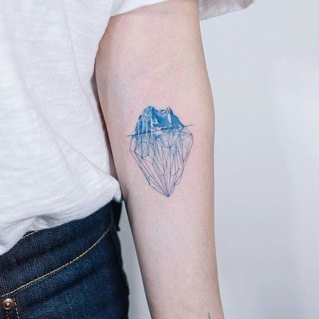 9 Blue Iceberg Tattoos with the largest part underwater in the form of a metaphor on the arm