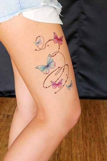 Tatuaje en Muslo de Mujer Mariposas rosas y celestes y espirales