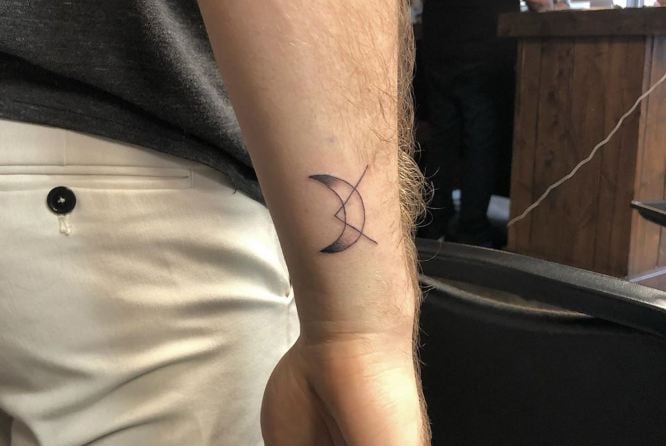 Pequenas tatuagens de meia-lua para homens na parte de trás do pulso com triângulo sobreposto