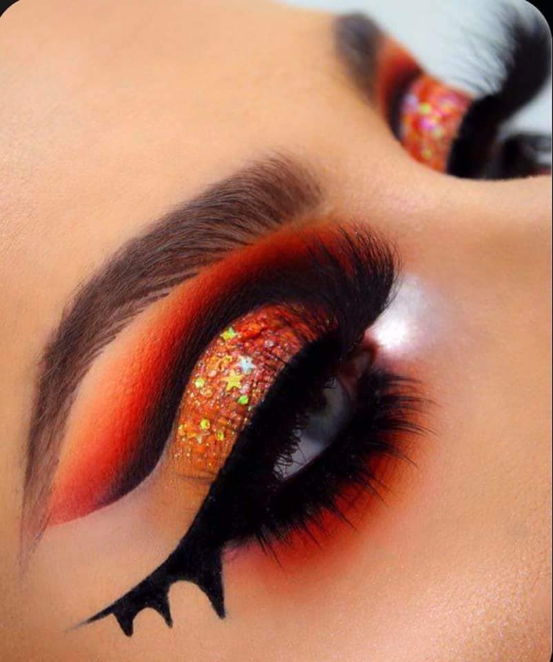 14 Halloween-Make-up auf den orangefarbenen Augenlidern mit Glitzer und schwarzen Fledermausflügeln mit Farbverlaufsschatten