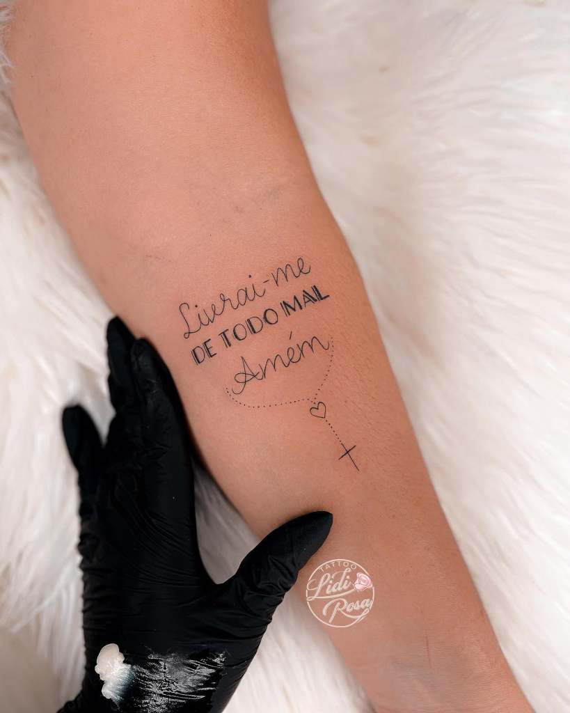 21 Rosario tatuaggio dell'artista Lidi Rosa con la scritta Liberami da ogni male Amen e piccola croce sull'avambraccio