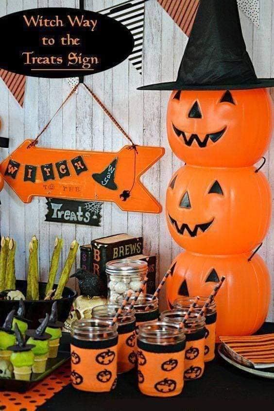 23 Ideas para celebrar Halloween en casa Rincon preparado con calabazas libros antiguos negros refrescos con taza de calabaza negro y naranja