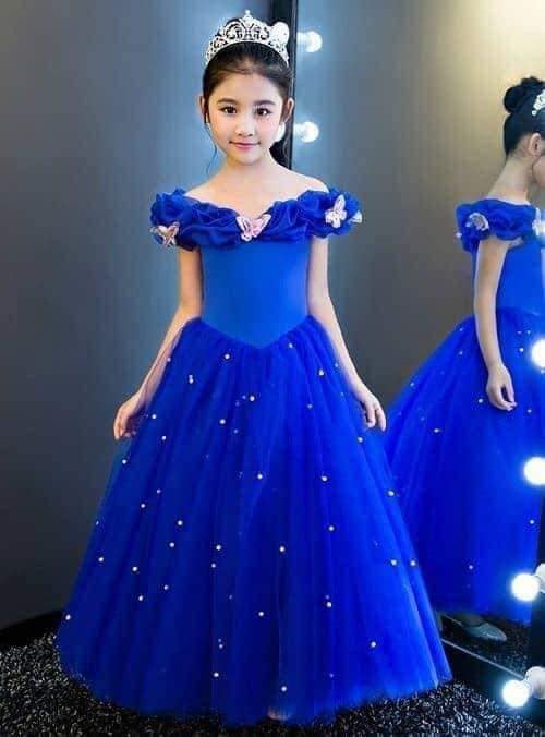 24 Moça com vestido sino azul com pequenos enfeites esféricos brancos, coroa e macacão