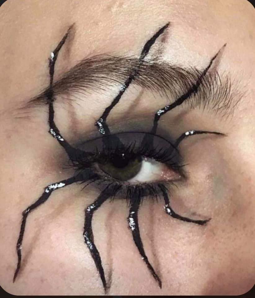 25 Maquillaje Halloween Ojo con sombra negra y dibujo de patas de arana saliendo del ojo blanco y negro
