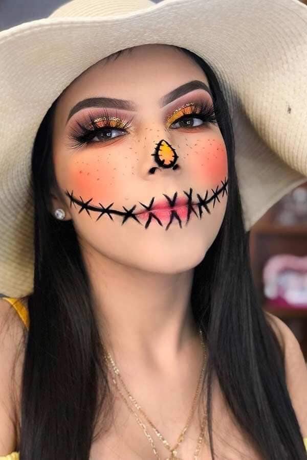 31 Halloween-Make-up. Geschlossener Mund, aufgenäht mit schwarzen Kreuzen, Nase und orangefarbenem Stoffaufnäher