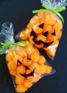 6 Ideas para celebrar Halloween en casa Bolsitas pintadas con ojos nariz y boca de calabaza con snacks naranjas