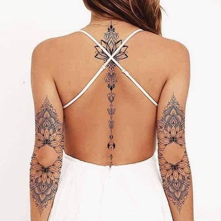 6 Female Lotus Flower and Unalome Tattoos along the black spine and Mandala on both arms at elbow height