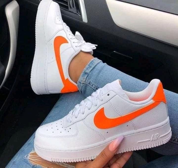 7 tênis Nike Air Force cor branca com logotipo laranja intenso