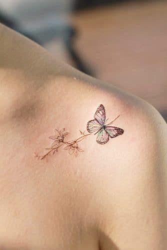 53 Tatuagem no ombro e clavícula delicada borboleta preta e azul claro com flores marrons