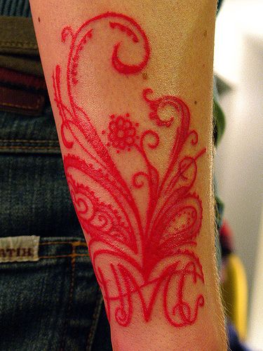 Tattoos mit roten Tintenornamenten und Buchstaben HMC
