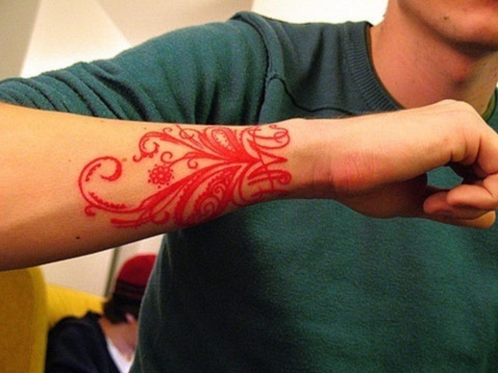 Tattoos with Red Ink Letters and ornaments on forearm and wrist