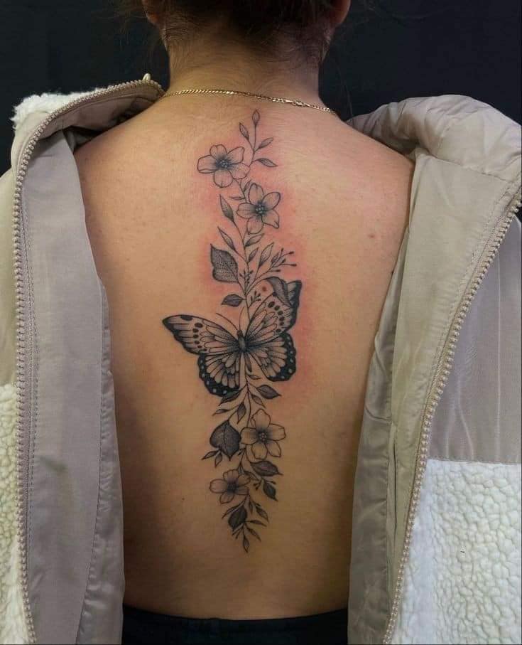 152 schwarze Tattoos auf dem Rücken entlang der Wirbelsäule, Schmetterlingsblumen und Zweige