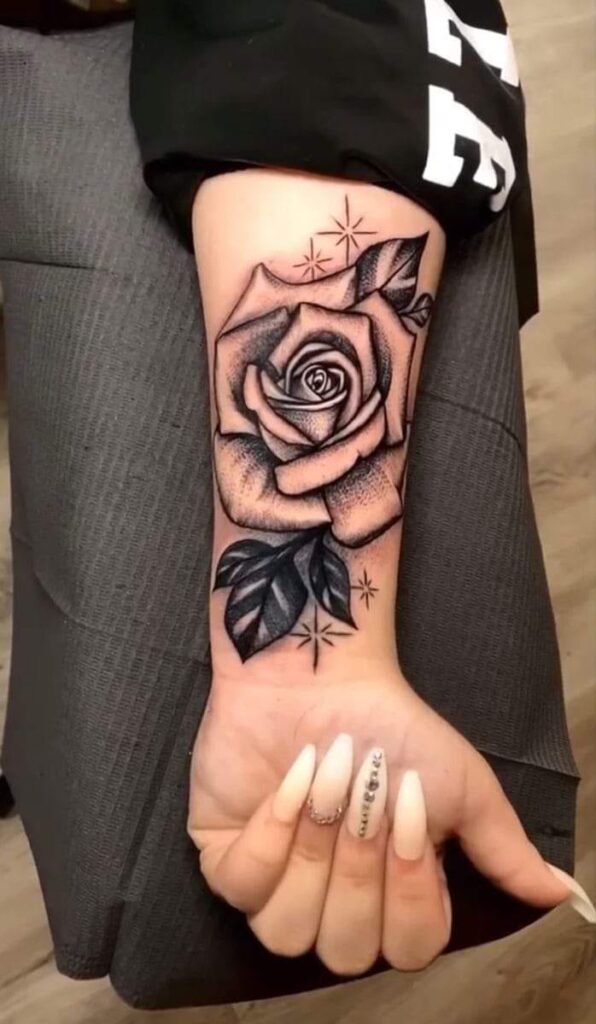 282 schwarze Tattoos am Handgelenk. Große Rose mit Blättern und Sternen