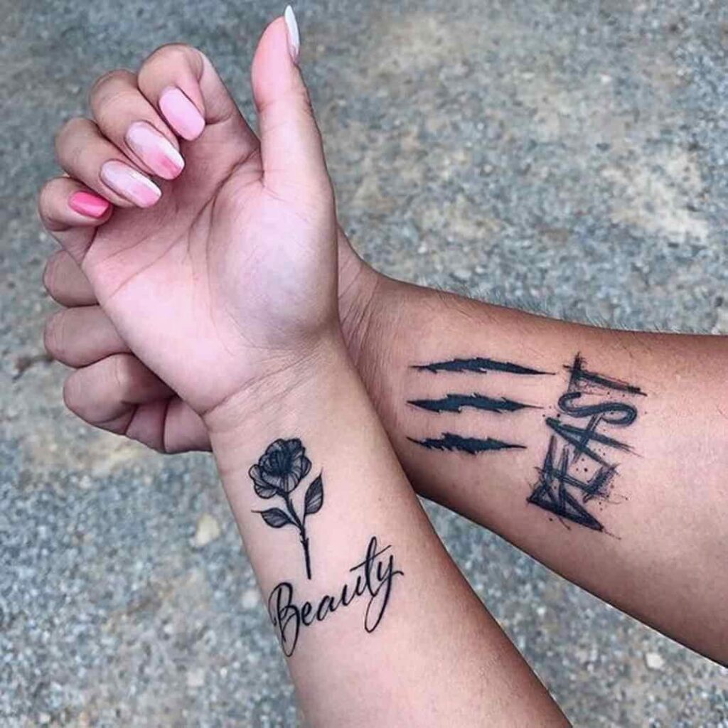 36 Schwarzes Tattoo auf beiden Handgelenken in einer schwarzen Rose mit dem Wort Bella und in einem anderen Zeichen mit dem Wort Beast